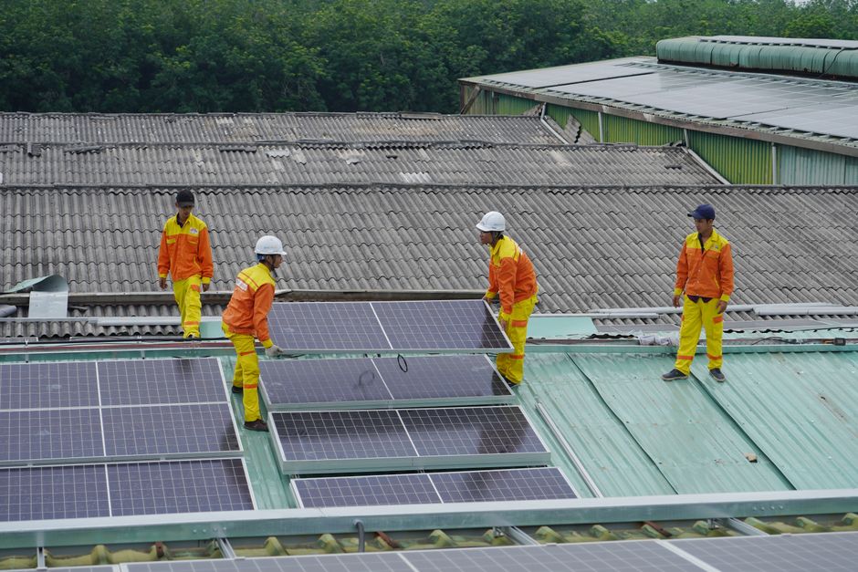 Solar installation workers carefully mounting solar panels